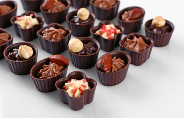 Delicious chocolate candies on white background