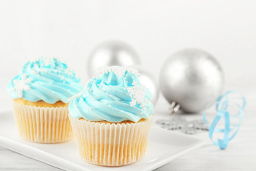 Few tasty blue cupcakes with decorations on light background