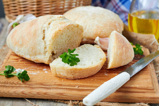 Fresh bread ciabatta on a cutting board and olive oil