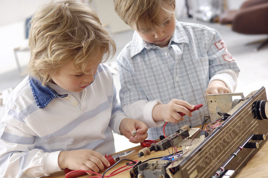 Two little boys disassembling an old radio