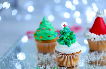 Christmas cupcakes with lights on background