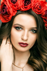 Fototapeta premium Pretty woman with wreath of red rose
