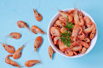 Prepared shrimp on a blue surface, top view