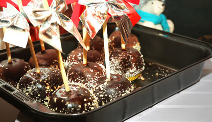 Tray of apples icing with chocolate at Christmas food kiosk