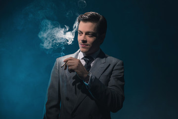 Vintage 1940s business man in suit and tie smoking cigarette aga