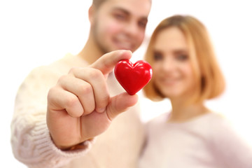 Young couple in love holding red heart, close up