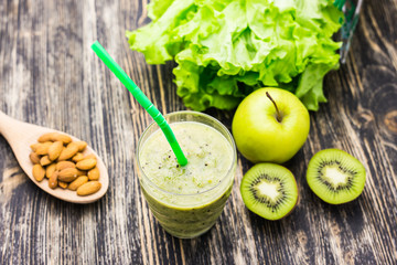 Healthy green smoothie with kiwi and apples on  wooden background