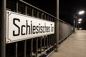 Deutschland, Berlin, Kreuzberg: Von Laternen in der Nacht beleuchtetes Schild Schlesisches Tor...