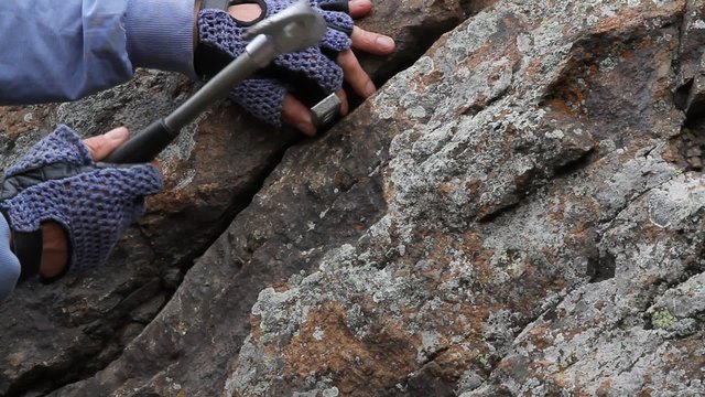 Hands the rock-climber with rope and equipment climbs on top 