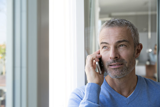 Mature man working from home using smart phone