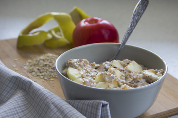 Tasty oatmeal with apples on wooden table