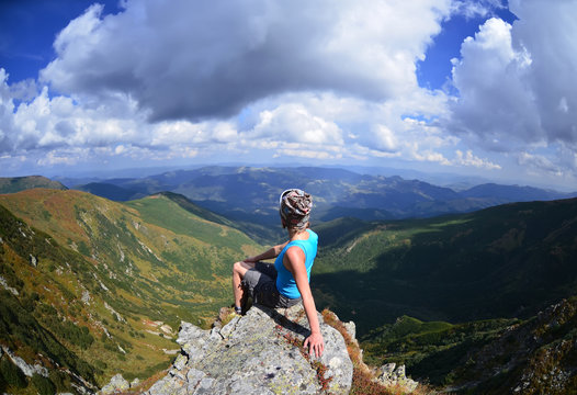 Young woman  sitting on a stone   in mountains, Carpathian ,Ukraine 