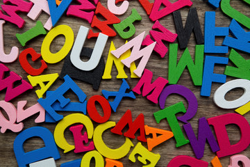 Surface covered with multiple colored wooden letters 