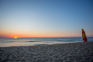 Surfbrett im Sonnenaufgang am Meer