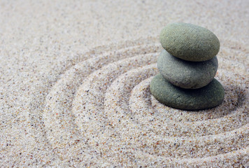 Fototapeta na wymiar Stacked zen stones with spiral sand