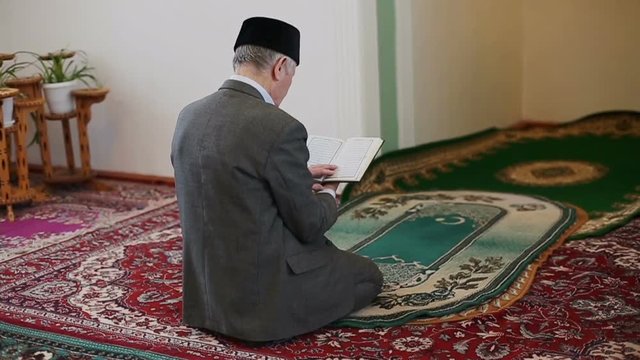 An old mullah reading the Koran in mosque. Slow motion