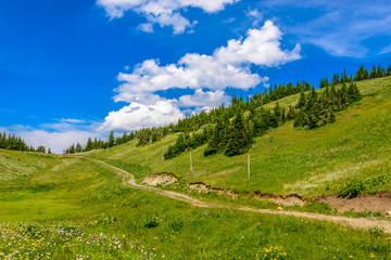 Beautiful landscape of valley in Alpine mountains, small trail, hike root, majestic picturesque view in sunny day