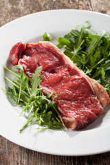 rohes Steak auf Rucolasalat