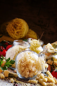 Dry Italian pasta spiraline in glass jars, selective focus