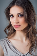 Naklejka premium Beautiful woman face close up portrait young studio on gray. Natural beauty