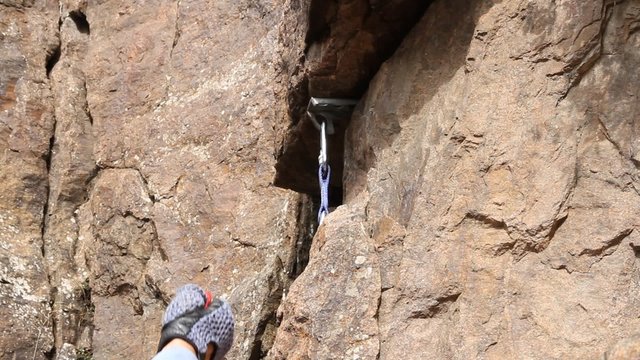 The climber organises safety point in a rocky crevice