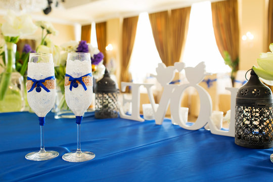 Wedding glasses decorated with lace and blue satin ribbon