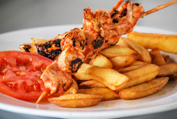 Brocheta de pollo con patatas fritas