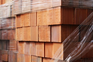 Close up delivery of red bricks for construction of new home by builders