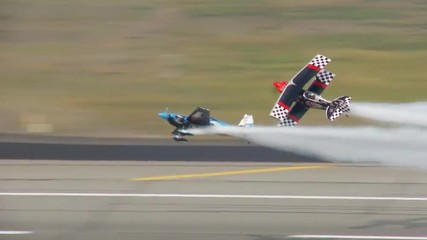 Two biplanes perform a dangerous stunt at an airshow.