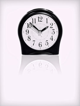 Alarm clock with reflection on white background.