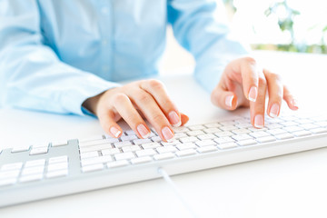 Woman office worker typing on the keyboard