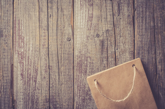 Overhead Shot Of Paper Gift Bag On Wooden Table