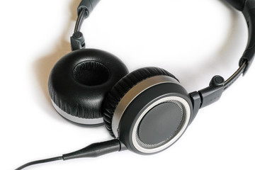 Black headphones on white background.Close-up view of modern earphones with cable.