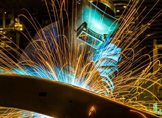 worker with protective mask welding metal