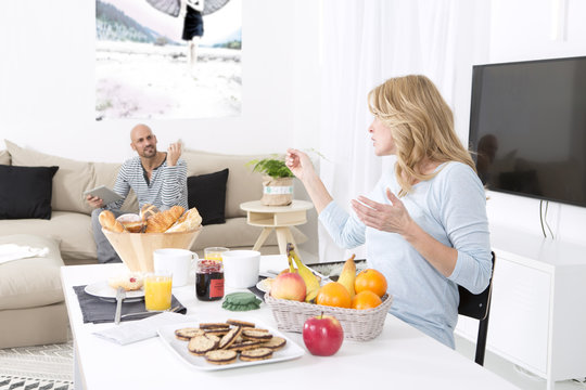 Mature couple quarreling at breakfast table