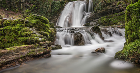 Fototapeta premium Beautiful mossy woodland waterfall; Janet's Foss in North Yorkshire, UK.