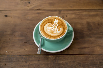 hot cappuccino with latte art on wood background
