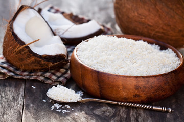 Cracked  coconut and flakes on rustic wooden table background