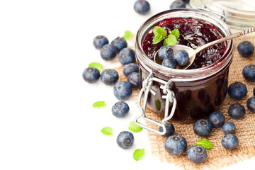 homemade  blueberry jam in a jar and fresh blueberries isolated