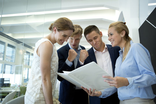Successful business team in office looking at folder