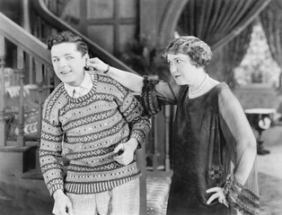 Woman pulling a man's ear 