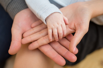 Fototapeta premium father and mother hold in their hands a little newborn baby's ha