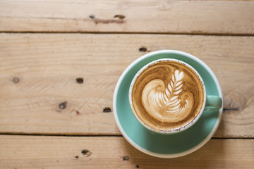 hot cappuccino with latte art on wood background