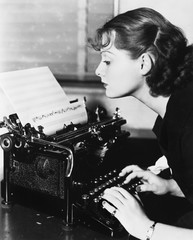 Profile of a young woman typing musical notes with a typewriter 