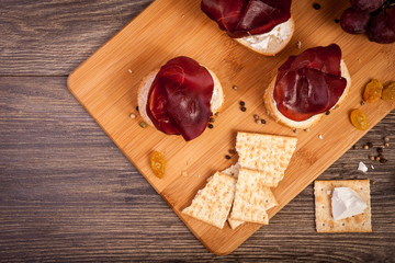 Top view of plate with ham, crackers and grape