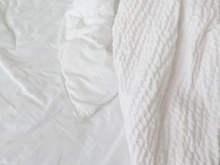 Detail of bed with set of white morning bedding