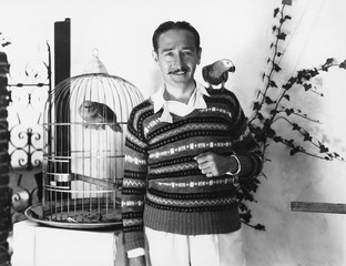 Man posing with pet birds 