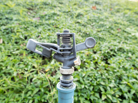 close up of sprinkler in green grass garden