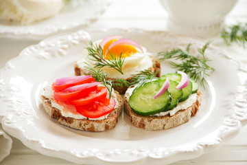 Appetizer sandwiches and cheese and vegetables.