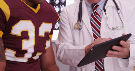 Close-up of medical doctor looking at tablet computer with sport